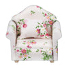 A white mini sofa and pillow set with pink floral fabric for a dollhouse