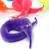 A purple fuzzy magic worm toy is shown against a white background with other colored worms visible in the background.