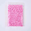 A clear plastic bag filled with numerous pink plastic beads or filler for crafting.