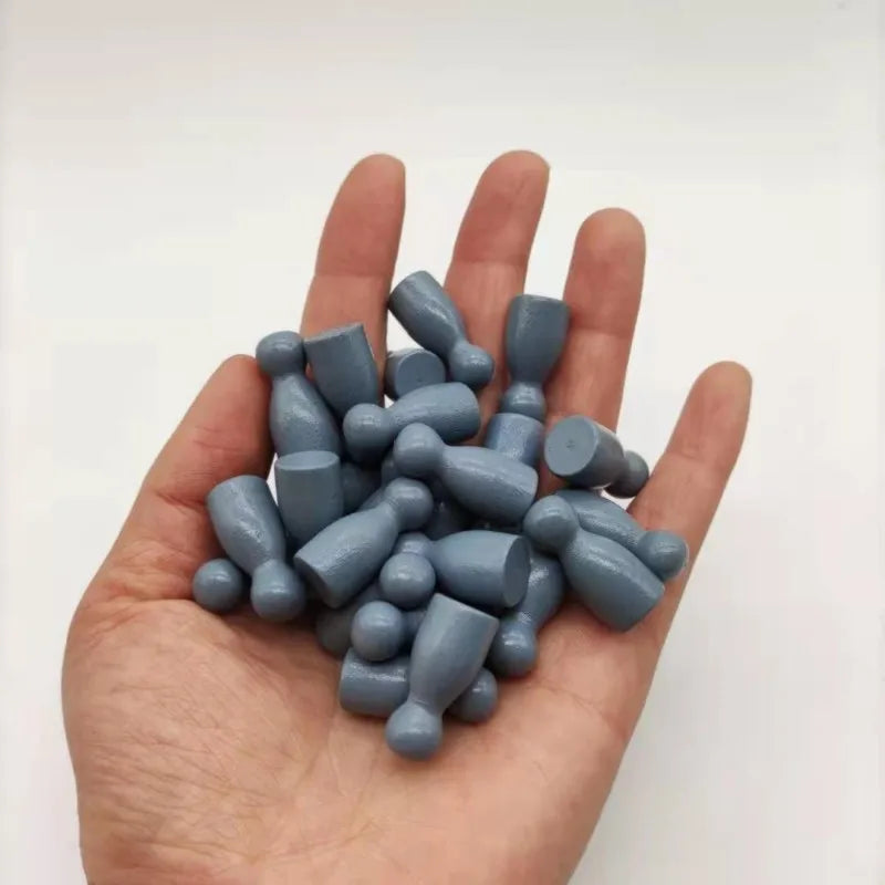 A hand holds a set of ten wooden chess pawns in a muted blue-gray color.