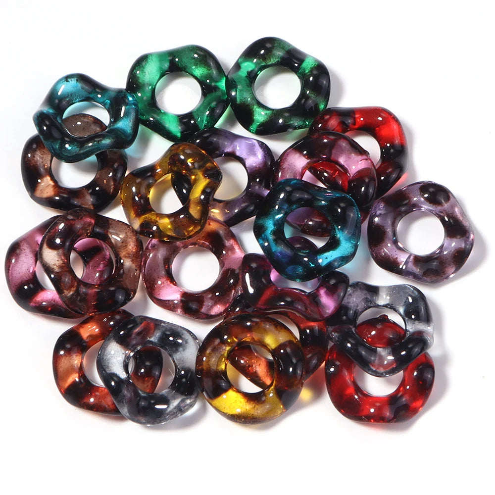 Assortment of candy colored acrylic spacer beads in various shades of green, purple, and red.
