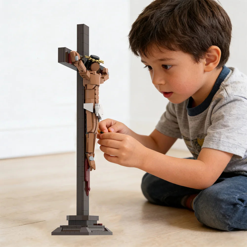 A young boy is assembling a 336-piece Jesus Crucifixion collectible model made of gray building blocks.