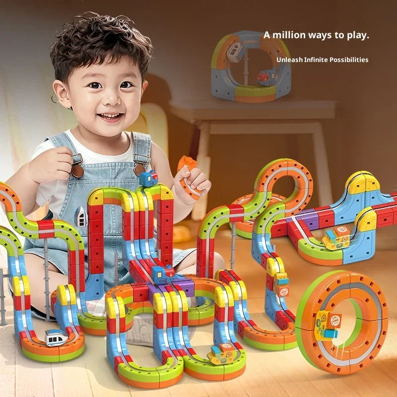 A young boy is playing with a colorful magnetic anti-gravity train track set featuring glowing rails and various track pieces