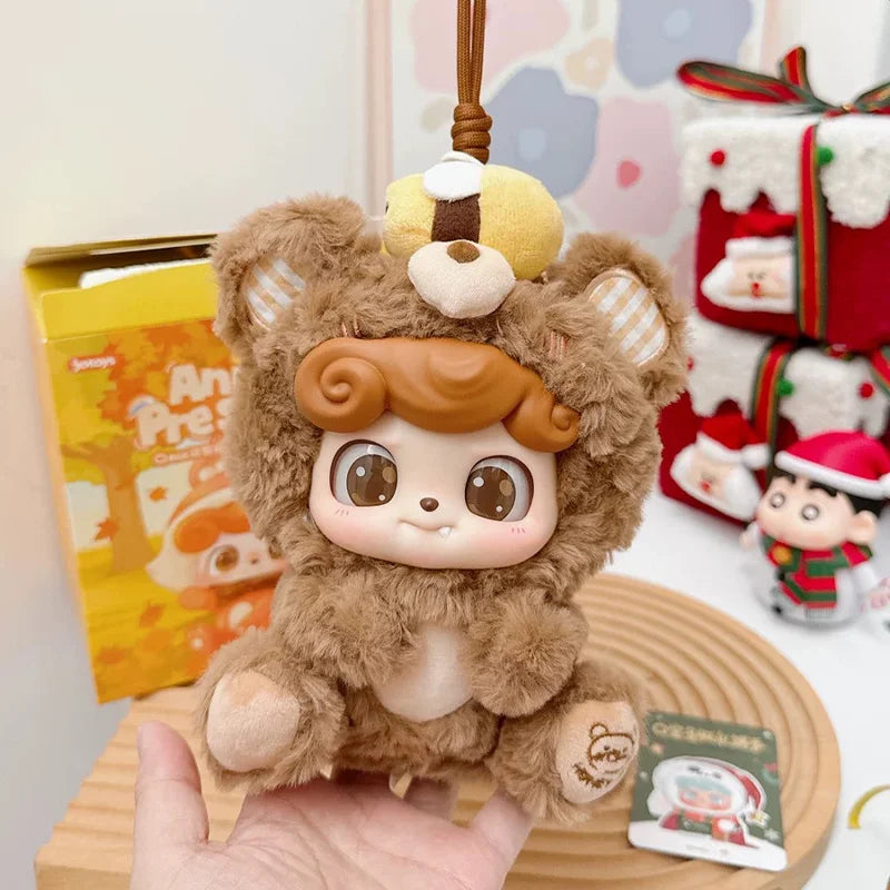 A fluffy brown animal plush doll with large eyes is displayed on a wooden surface.