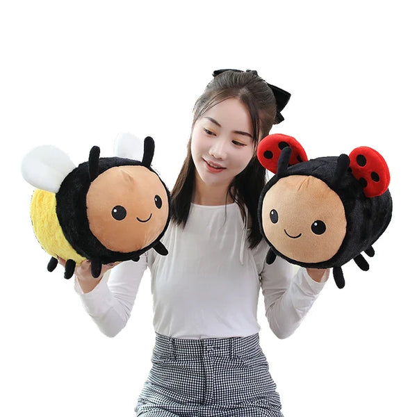 A woman holding a black and yellow bee ladybug plush toy with white wings.