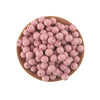 A pile of pink silicone round beads for jewelry making and DIY crafts arranged on a wooden surface.