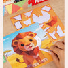 A hand is assembling an animal puzzle kit featuring a lion design and puzzle pieces on a wooden surface.