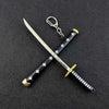 A samurai sword with a silver blade and black grip featuring white crosses, attached to a metal keychain.