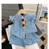 A light blue floral print girls' sleeveless shirt and shorts set displayed on a wooden hanger.