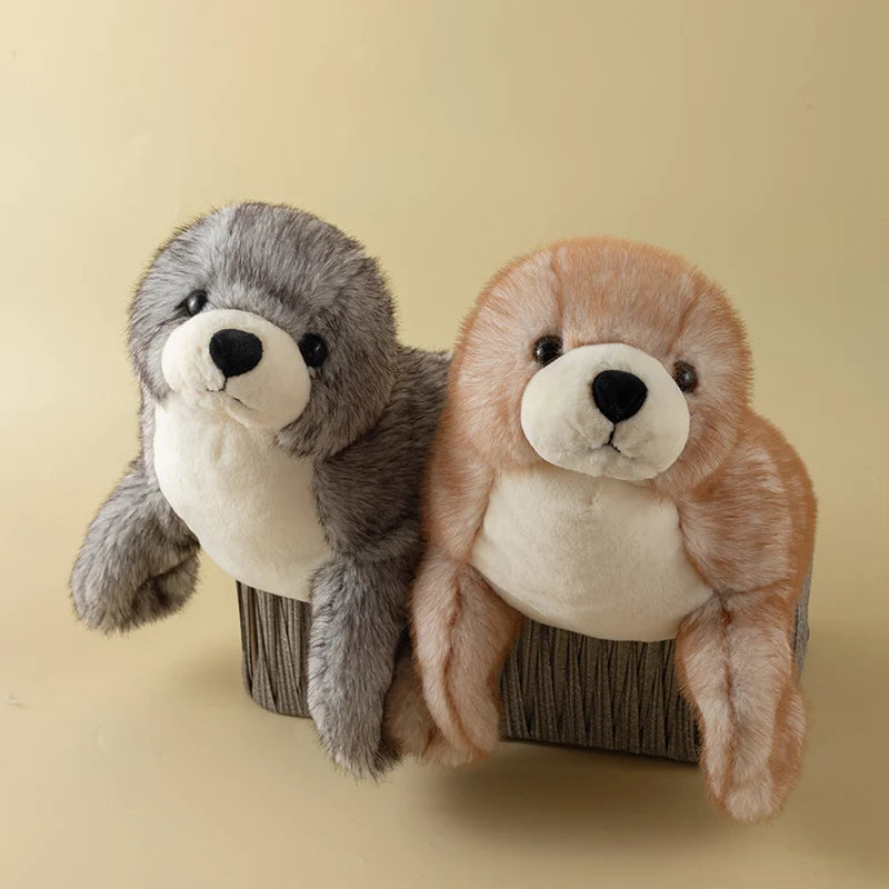 A pair of realistic seal plush toys, one gray and one light orange, sitting side by side.