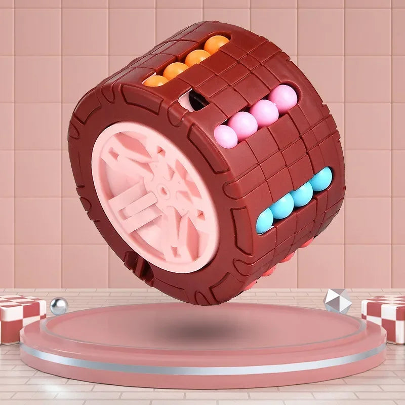 A brown cube shaped like a rotating slide puzzle with pink and blue balls, resting on a light pink circular platform.