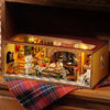 A wooden miniature dollhouse kit with a glass display showing a detailed interior scene.