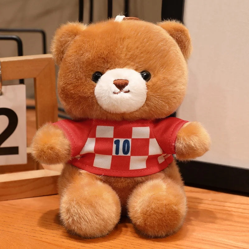 A fluffy brown teddy bear wearing a red and white checkered football jersey with the number 10