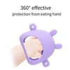 Une main tient un jouet de dentition en silicone violet conçu pour se protéger de la main qui mange.