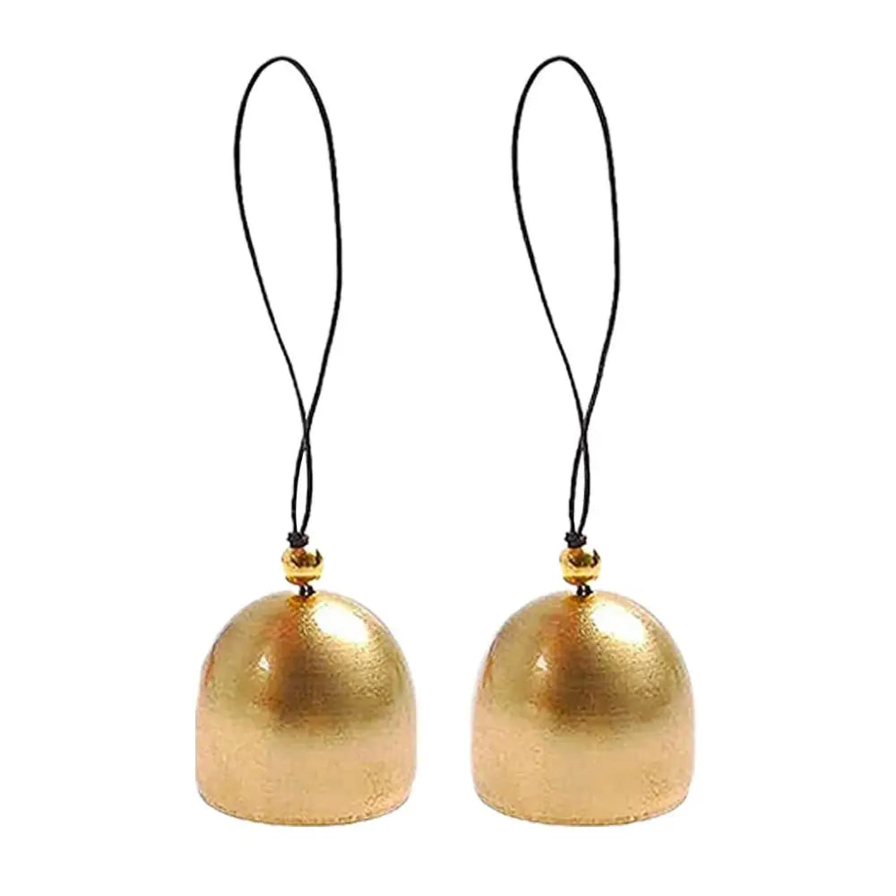 A pair of handcrafted Tibetan singing bowls with black cords and gold accents.