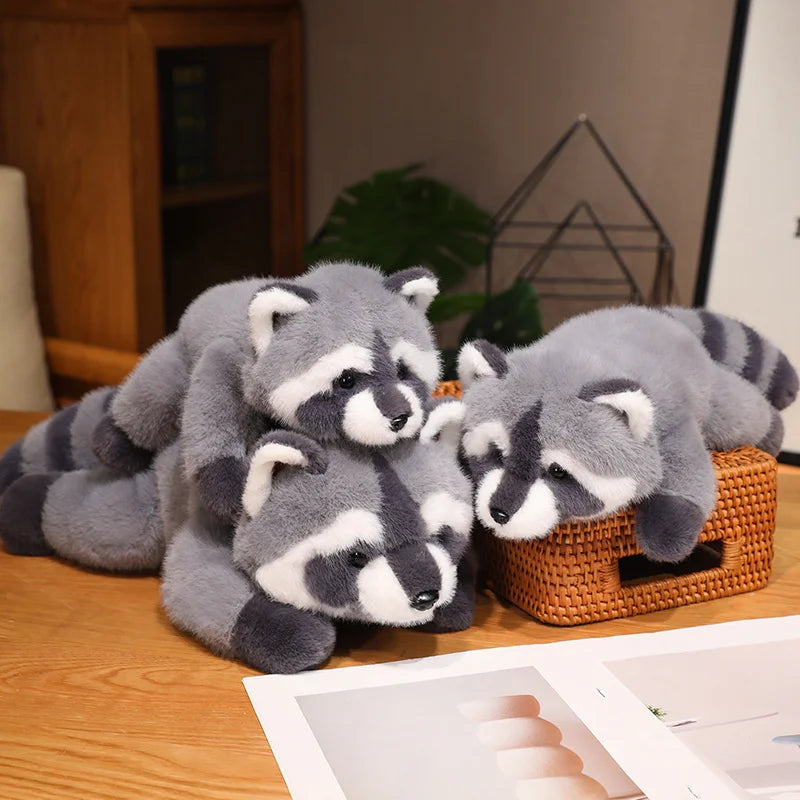 A pile of gray and white raccoon plush toys resting on a wooden surface.