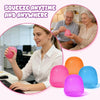 A woman is squeezing a pink squishy stress ball while working at a desk, with various colored squishies displayed nearby.