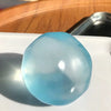 A translucent light blue squishy stress ball resting on a white surface.