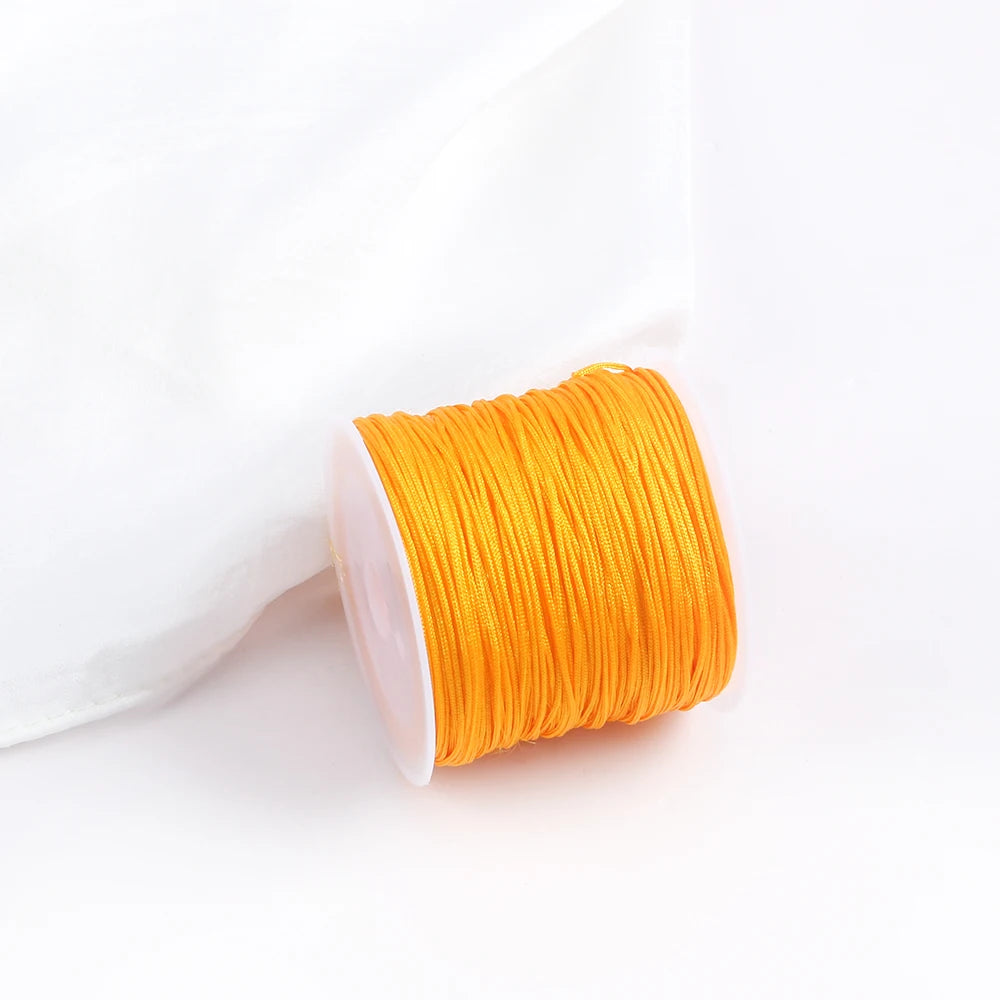 A roll of bright orange 0.8mm cotton nylon macrame cord for jewelry making and crafts.