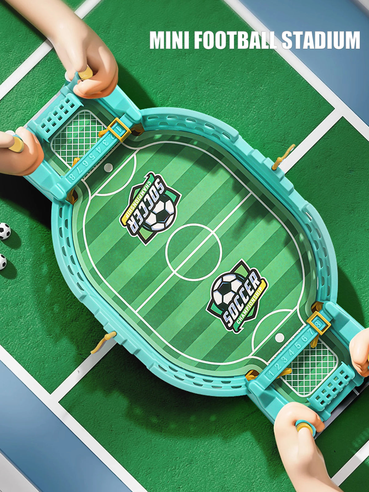 A hand holds a mini football stadium tabletop game with a green playing field and goal net on a green surface.