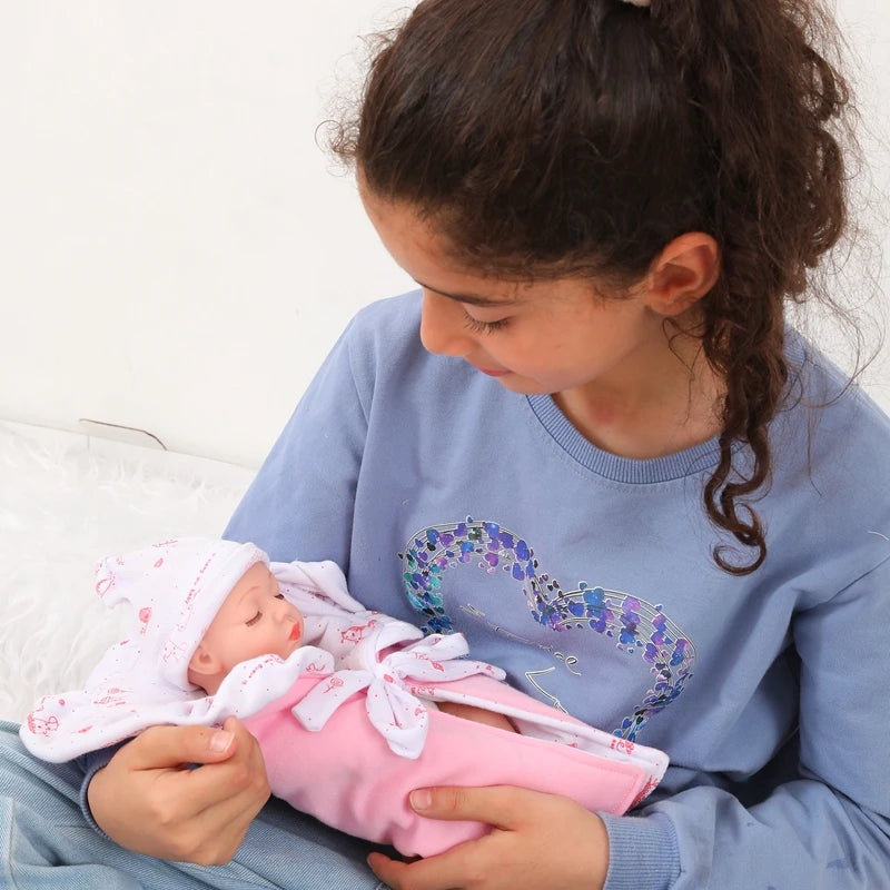 A young girl is holding a lifelike soft vinyl reborn doll with a pink outfit.
