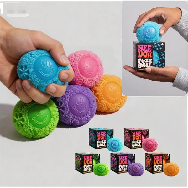 Eine Hand hält einen leuchtend blauen Fusselball-Stressball-Schreibtisch-Anhänger neben verschiedenen bunten Fusselbällen.