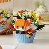 A building block set depicting an orange and black cat face with yellow flowers, arranged in a blue cup.