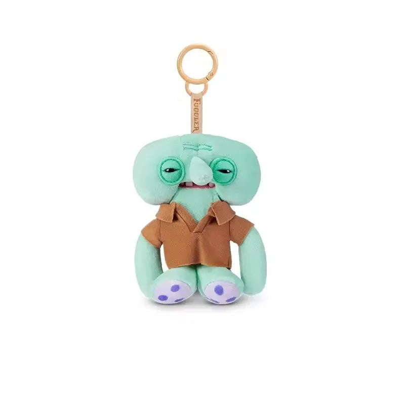 A cute green monster plush keychain with large eyes and brown clothing.