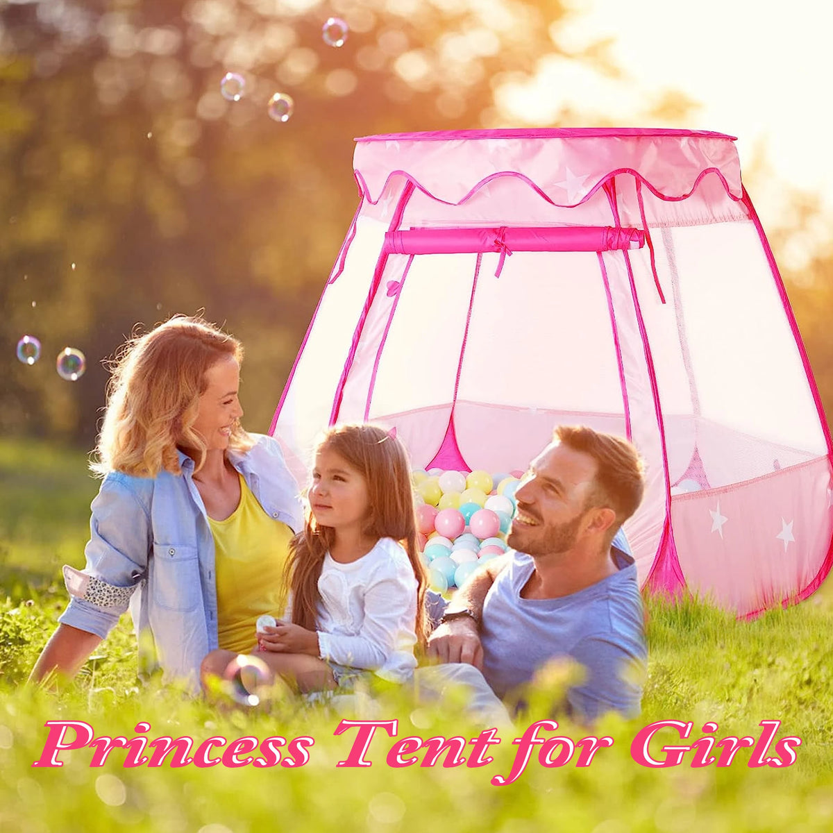 A family of three enjoying a pink princess tent outdoors in a grassy field with bubbles.