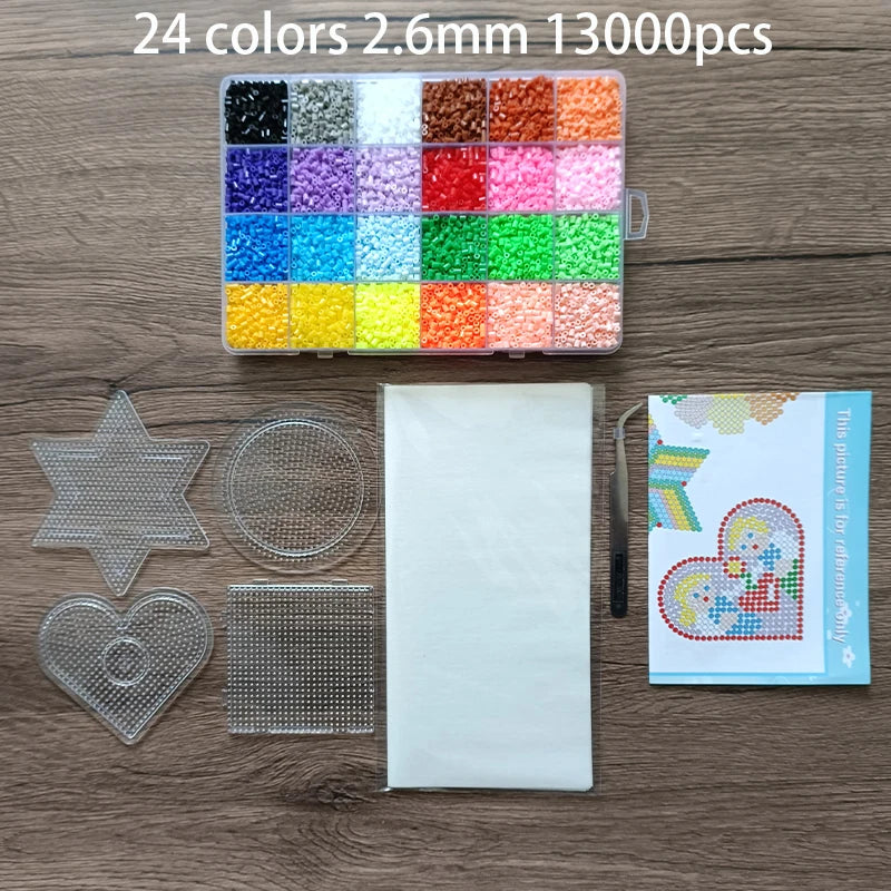 A box of 24 colors of 2.6mm fuse beads and various shapes including stars hearts and a sheet of clear beads