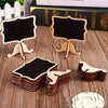 Mini wooden chalkboard signs with easels for weddings and parties displayed on a wooden surface.