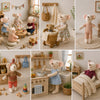 A collection of handmade mouse plush dolls dressed in various retro outfits and sitting in a cozy, rustic setting.