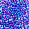 A close-up view of many round glass crackle beads in various shades of blue and purple.