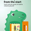 A green, dinosaur-shaped electronic learning machine with a card slot and a screen is shown.