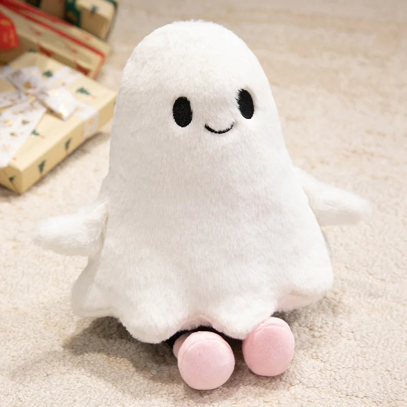 A white ghost plush toy with black eyes and pink feet sitting on a light-colored surface.