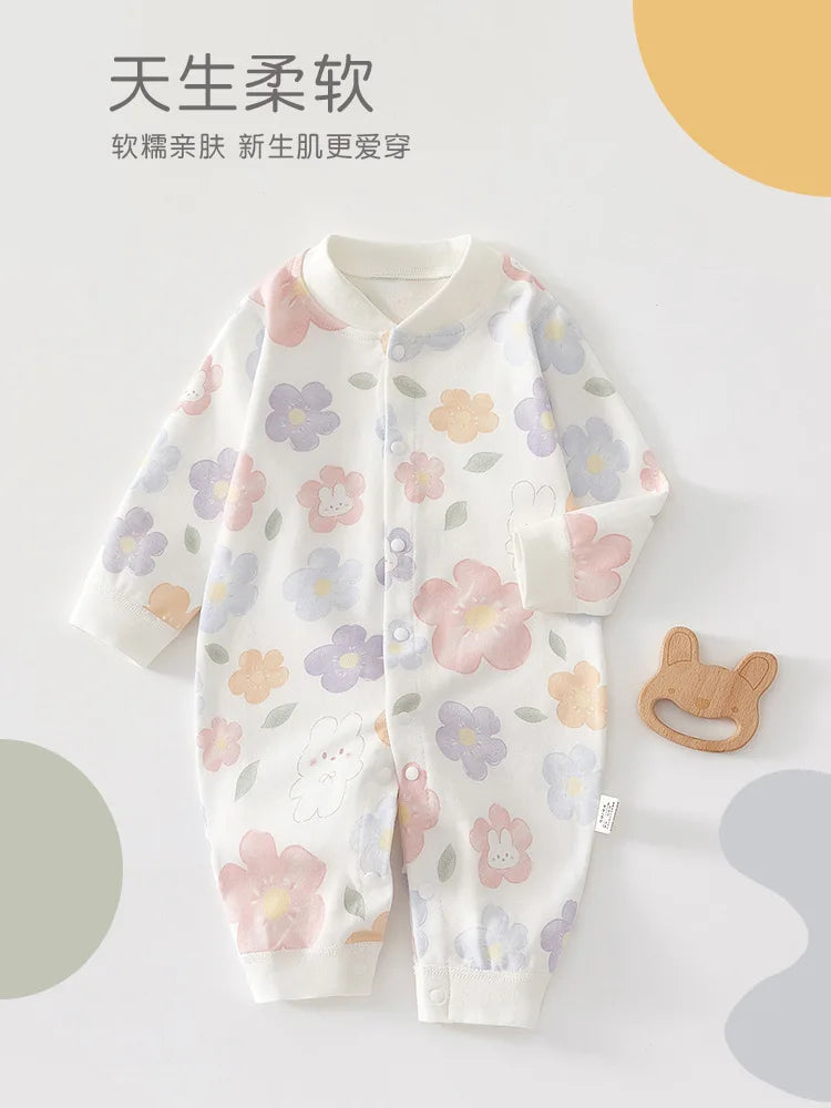 A white cotton long sleeve baby romper featuring a floral pattern of pink, purple, and yellow flowers.