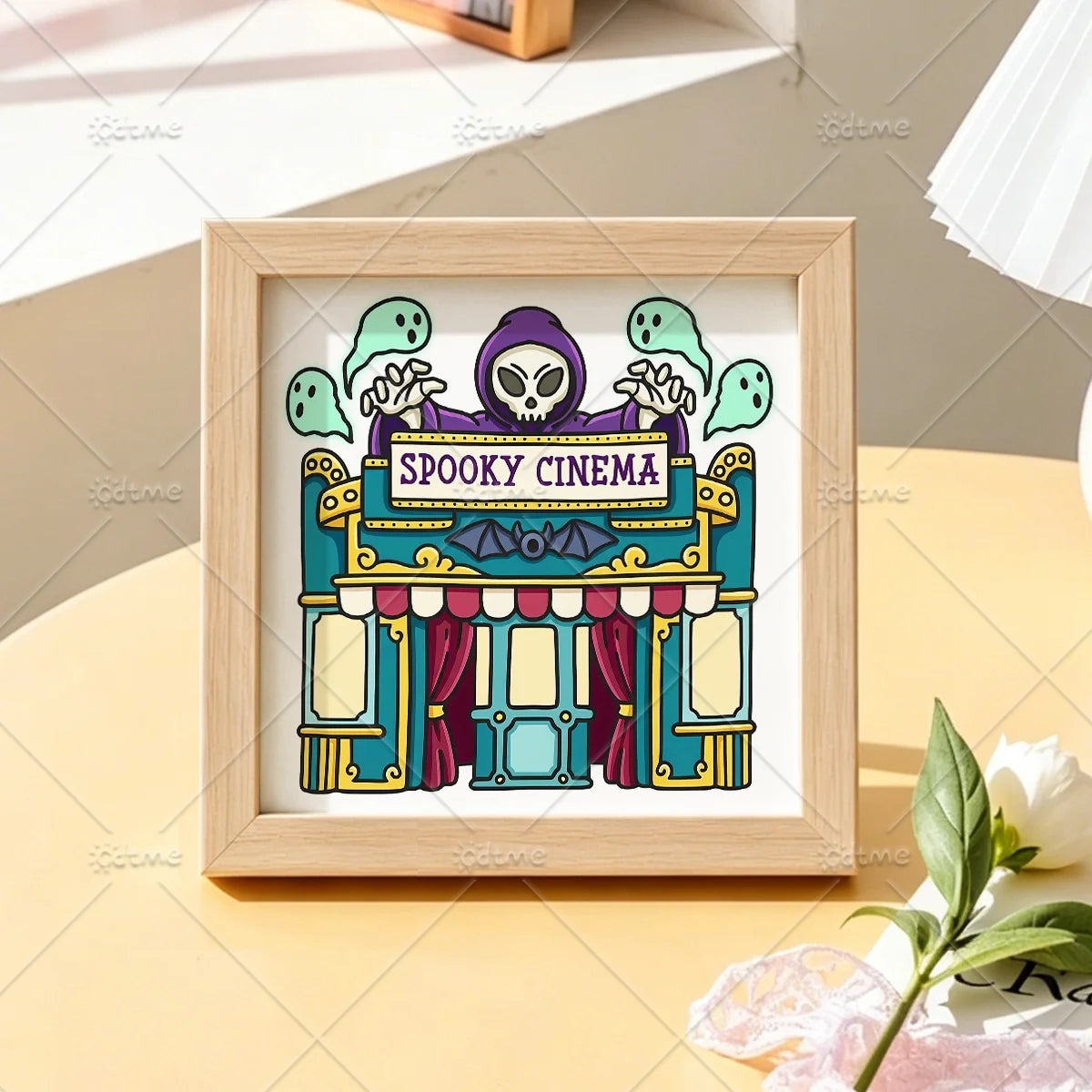 A framed illustration of a spooky cinema facade with a purple ghost and skull, featuring the text SPOOKY CINEMA.