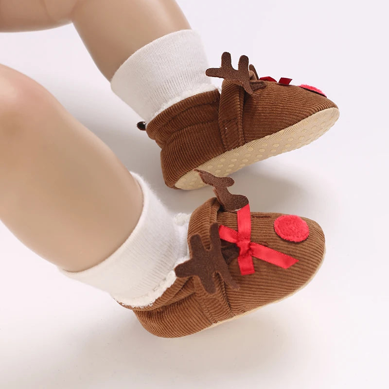 A pair of brown animal-themed baby first walker shoes with white socks shown from the side.