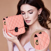 A woman holds a pink quilted bag featuring vintage metal D-ring buckle clips.