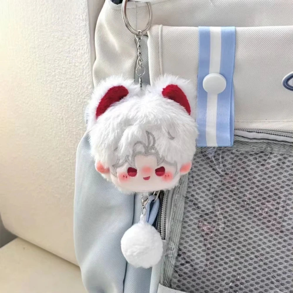 A white fluffy plush pendant keychain with red ears and a small face, hanging from a light blue fabric strap.