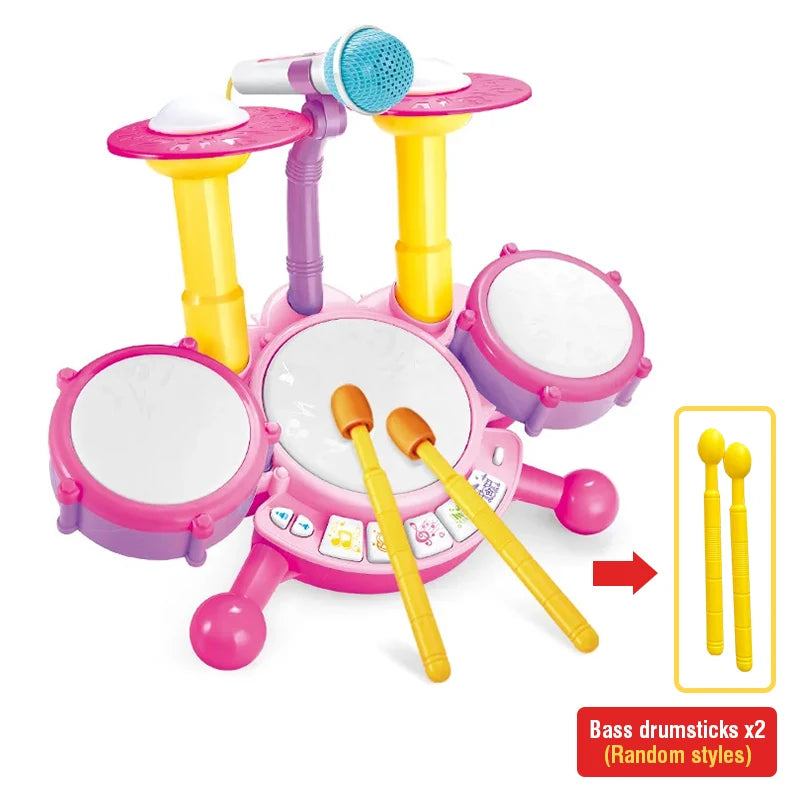 A pink interactive kids drum set with light-up pads and a microphone, featuring various drumsticks.