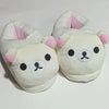 A pair of white Rilakkuma plush indoor slippers with pink accents.