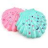 A set of multi-layer shell-shaped makeup toys in pink and teal colors.