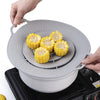 A hand places silicone spill stopper lids onto a cooking pot or pan.