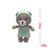A handmade crochet stuffed bear wearing a light green hood and overalls, shown against a white background.