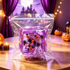 A clear plastic bag contains a purple fidget cube featuring festive Halloween and holiday characters like ghosts, pumpkins, a
