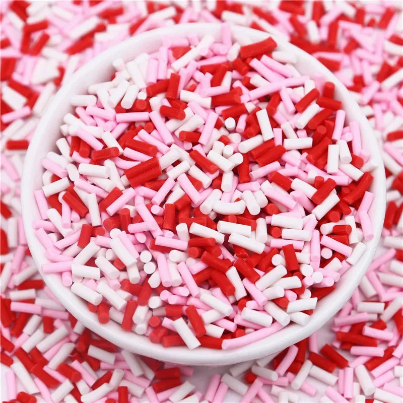 A bowl filled with red and pink polymer clay slice sprinkles for slime and DIY crafts