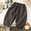 Dark gray fleece-lined pants with a subtle heart print laid out on a white surface.