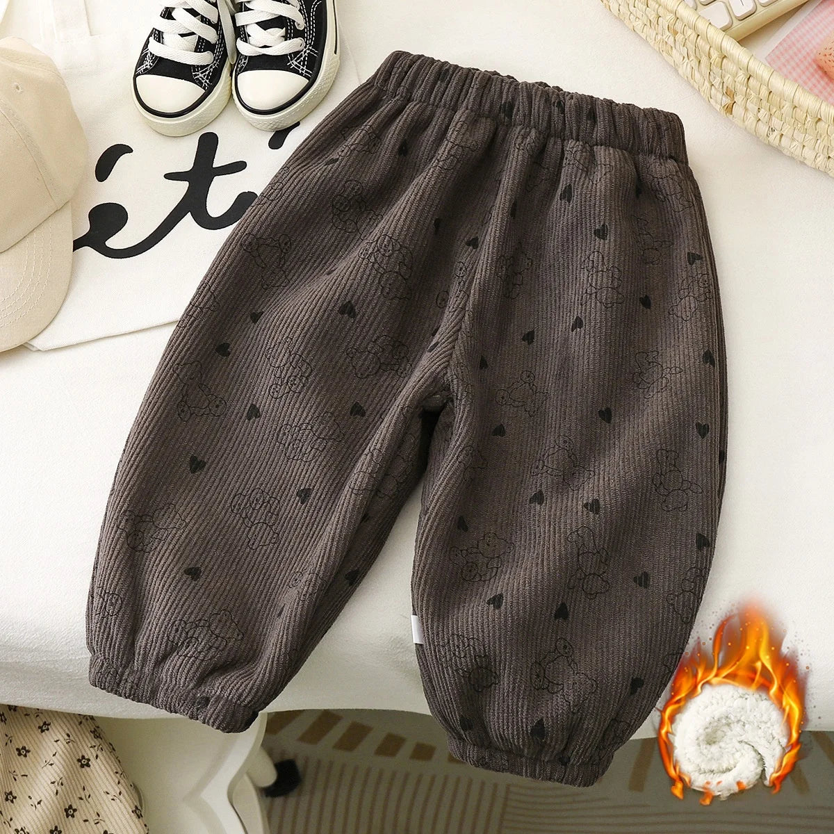Dark gray fleece-lined pants with a subtle heart print laid out on a white surface.