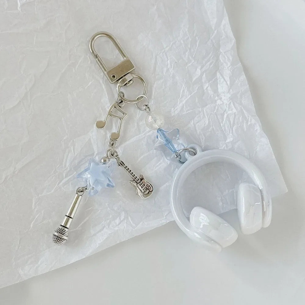 Silver beaded wing cross phone lanyard keychain attached to a white silicone earbud case